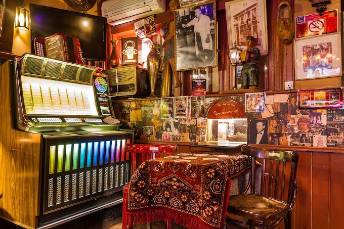 Un bar branché avec un jukebox et des photos annexes aux murs.
