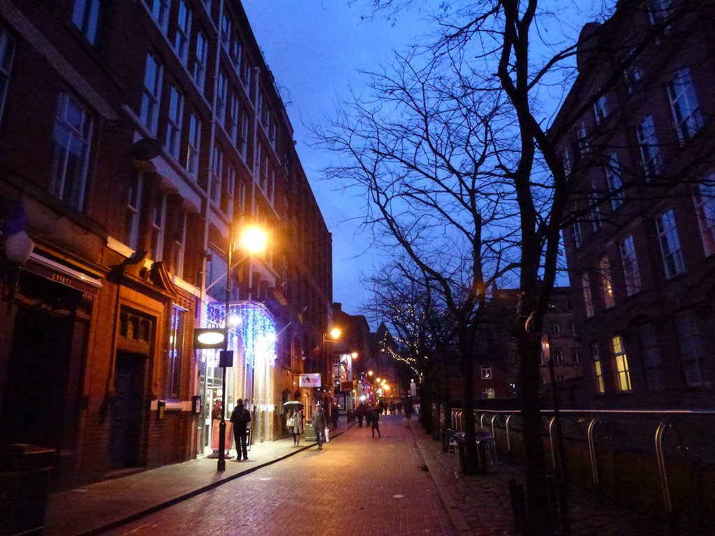 Une rue conviviale LGBTQ+ bordée de bâtiments en briques au crépuscule dans Canal Street à Manchester.