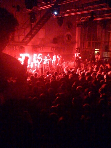 Une foule de personnes profitant de la vie nocturne de Berlin lors d'un concert gay dans une pièce sombre.
