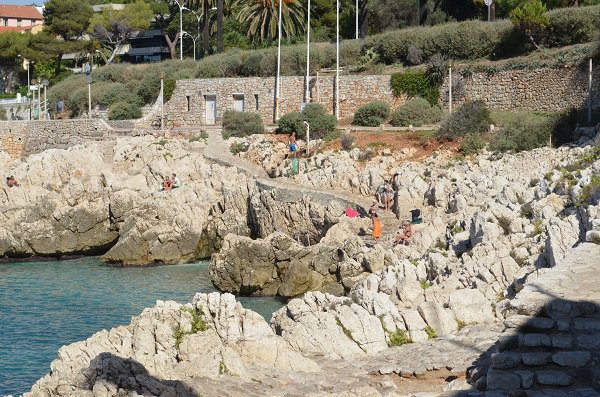 Un groupe de personnes se promène le long d'un rivage rocheux sur la Côte d'Azur.