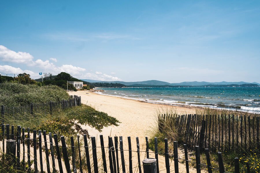 Une plage avec du sable et une clôture en bois sur la Côte d'Azur.
