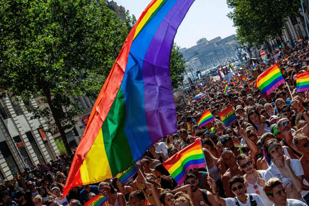 Un groupe de personnes gay-friendly agitant un drapeau arc-en-ciel à Marseille.