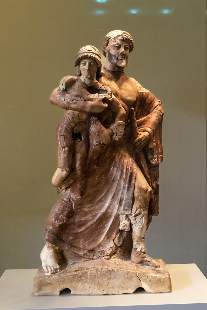 Une exploration LGBTQ+ des récits grecs anciens et mythologiques à travers une statue d'un homme tenant un enfant.