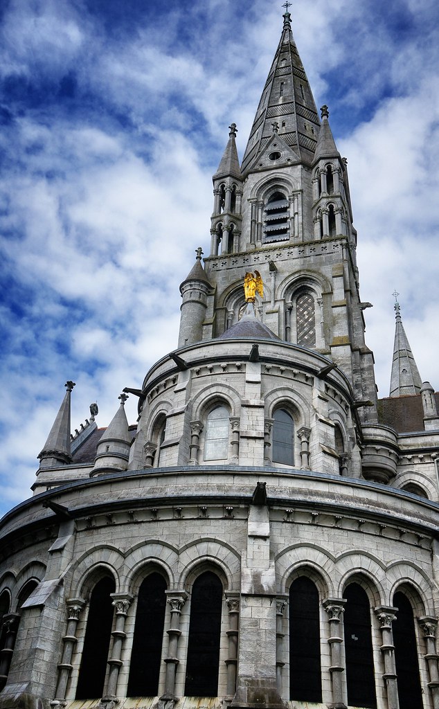 Une église ornée avec une tour de l'horloge en arrière-plan, présentant la vie nocturne et la scène culturelle de Cork.