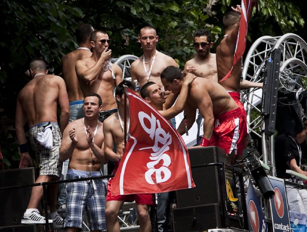 Un groupe d'hommes avec des drapeaux français célébrant pendant Pride in France 2023.