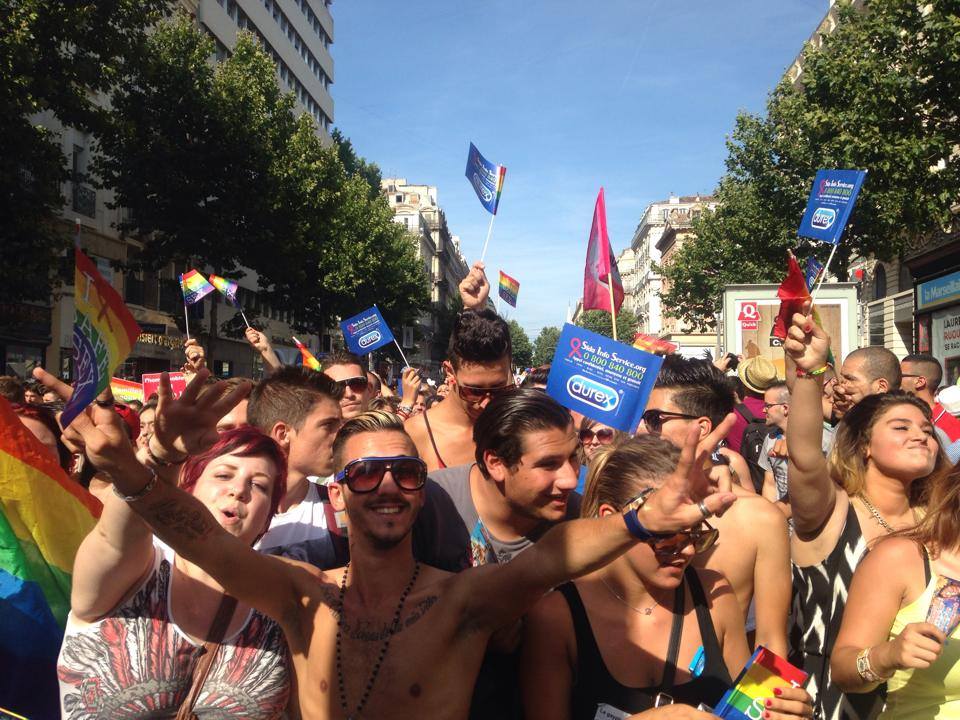Un groupe de personnes agitant des drapeaux dans la rue pour célébrer les dates des fiertés françaises en 2023.