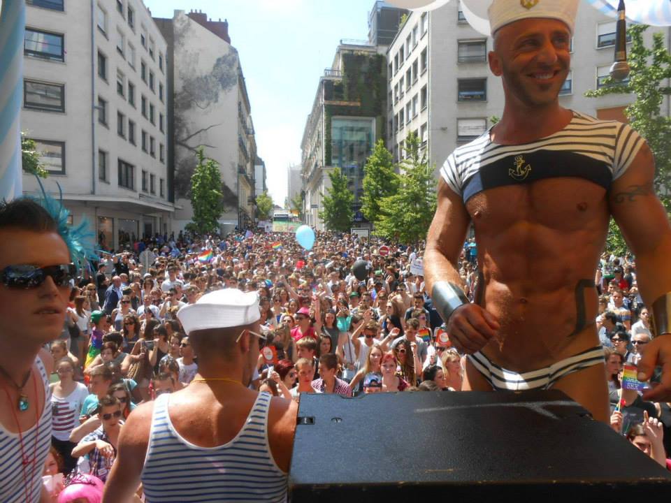 Un homme vêtu d'un marin debout devant une foule lors des dates des France's Prides 2023.
