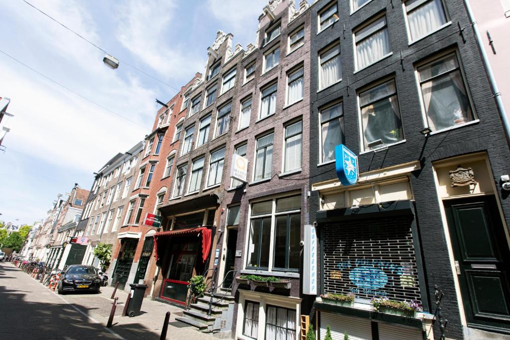 Une rangée de bâtiments dans une rue d'Amsterdam, présentée dans un guide de voyage gay.