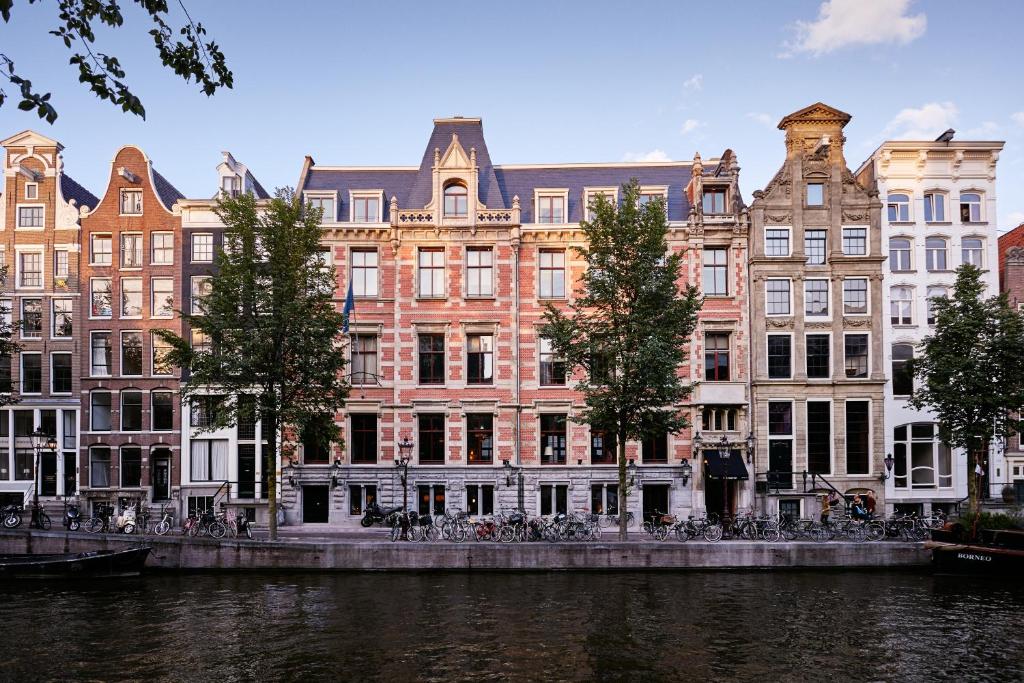 Une rangée de bâtiments sur un canal à Amsterdam, présentée dans un guide de voyage gay.