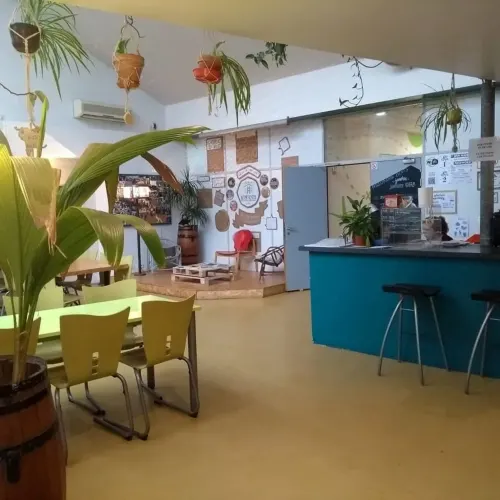 Une salle des guides Gay Lyon avec une table, des chaises et des plantes.