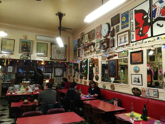 Un restaurant animé orné de nombreux tableaux aux murs.