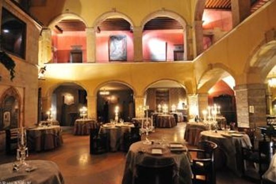 Un bâtiment orné de tables et de chaises dans une salle à manger, parfait pour le guide Gay Lyon.