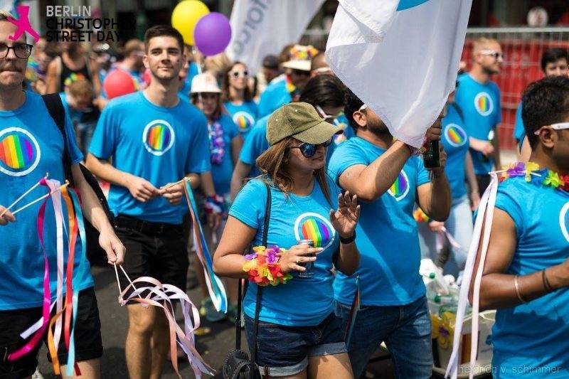 Un groupe de personnes en t-shirts bleus marchant dans le défilé de la fierté de Berlin.