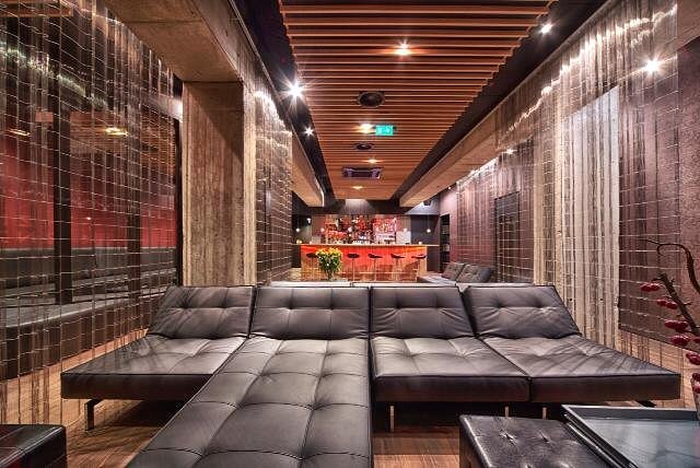 Un salon avec des canapés en cuir et un plafond en bois.