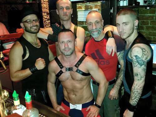 Un groupe d'hommes posant pour une photo dans un bar gay à Berlin.