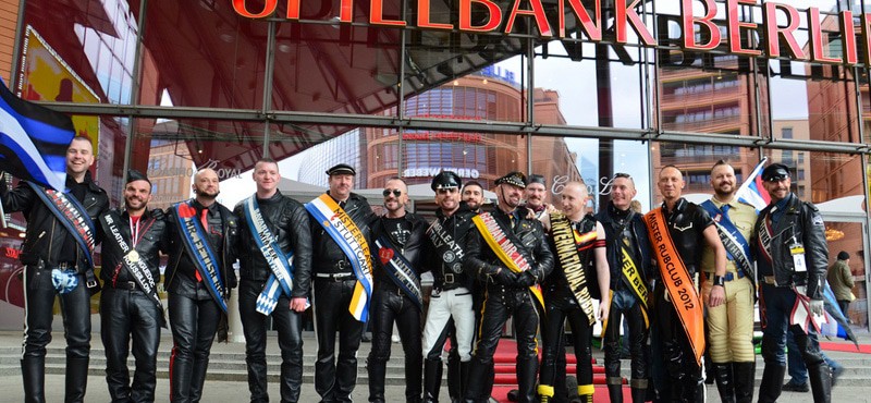 Un groupe d'hommes portant des vestes en cuir devant un club gay, présentant la scène LGBTQ+ dynamique de Berlin.