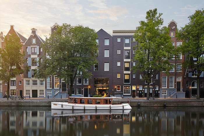 Un guide de voyage gay à Amsterdam mettant en vedette un bateau sur un canal.