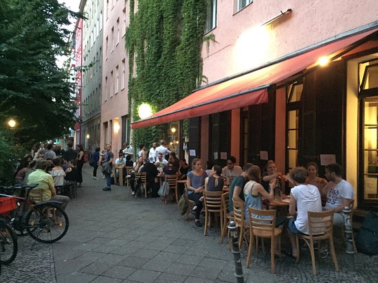 Un groupe de personnes appréciant la culture de rue dynamique dans le quartier gay-friendly de Berlin.