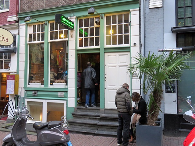 Un groupe de personnes se tient devant un magasin à Amsterdam.