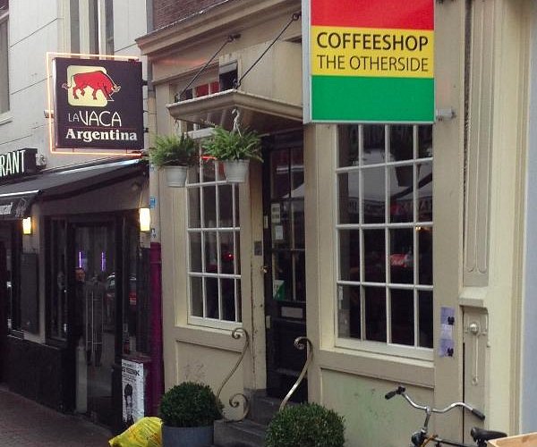 Un café gay-friendly à Amsterdam avec un vélo garé à l'extérieur.