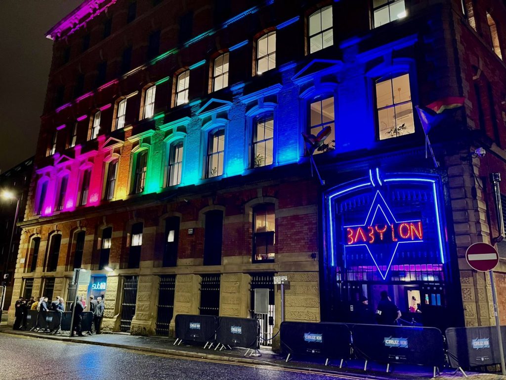 Un bâtiment de Manchester est éclairé par des lumières arc-en-ciel, servant de guide à la communauté gay.