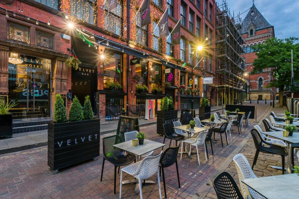 Un guide des restaurants gay-friendly de Manchester avec terrasse dans une rue en brique.