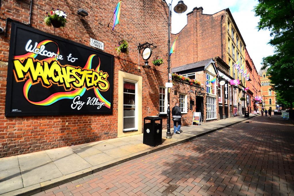 Un panneau de rue accueillant les visiteurs de Manchester City, servant de guide à ceux qui s'intéressent à la communauté LGBTQ+ dynamique de la ville.