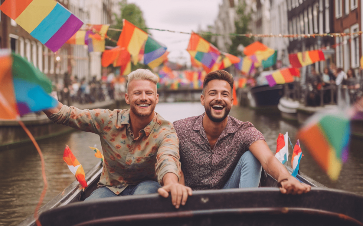 Deux hommes homosexuels dans un bateau au Canal Parade d'Amsterdam, agitant des drapeaux arc-en-ciel.