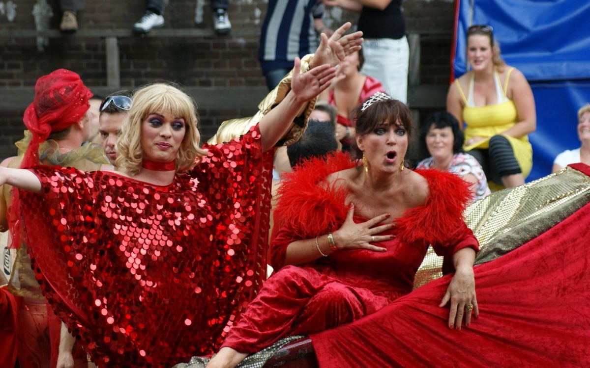 Deux femmes vêtues de rouge sur un char lors d'un défilé animé dans la vie nocturne gay d'Amsterdam.
